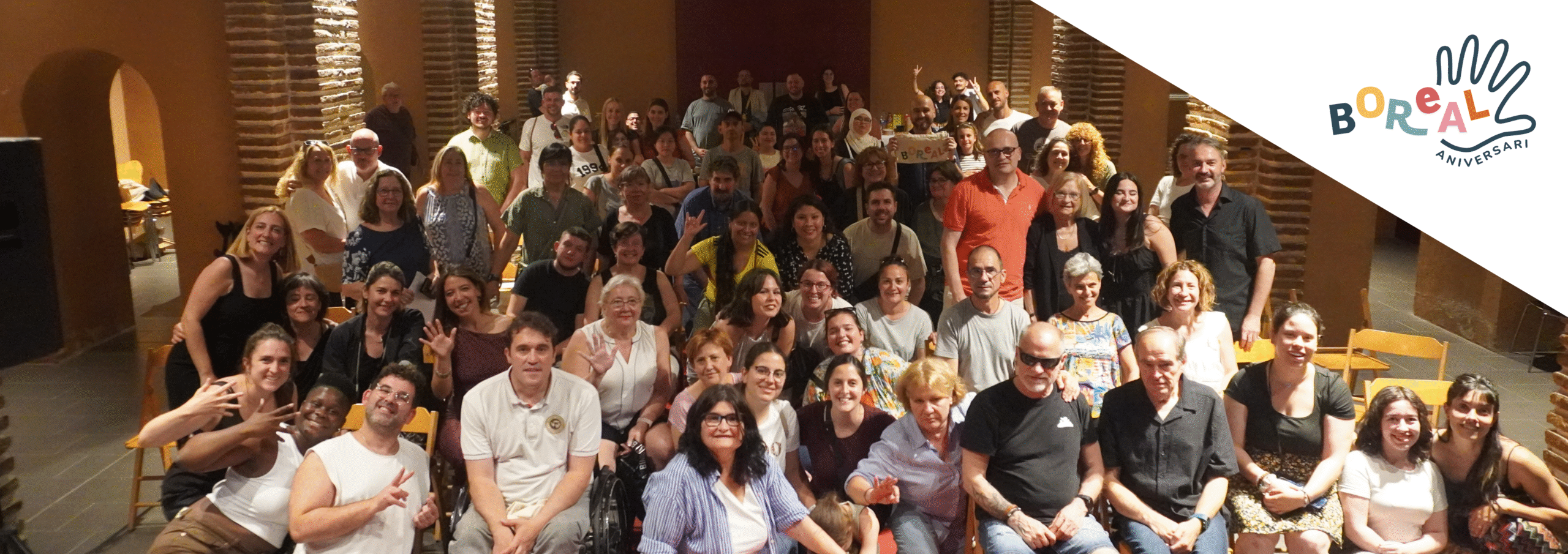 Foto de grup de persones en un esdeveniment de Boreal dins d’un espai interior amb el logotip de l’aniversari