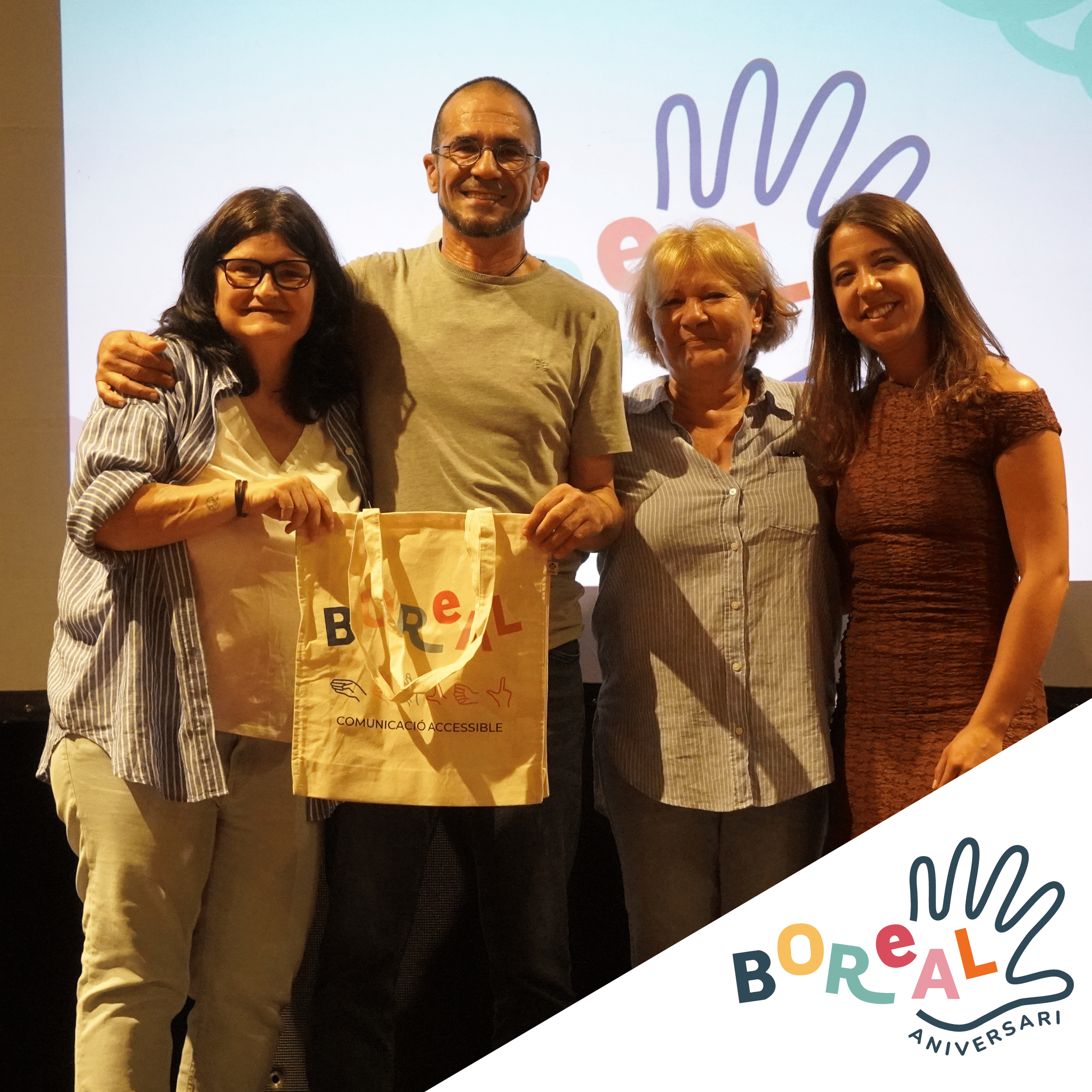 Foto de quatre persones en un esdeveniment de Boreal amb una bossa de comunicació accessible